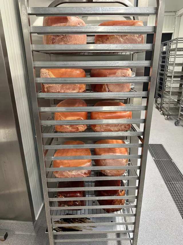 Rek met huisgemaakte gekookte en gebakken hammen in het atelier