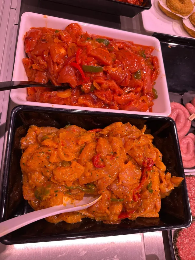 Schalen met gemarineerde reepjes kip en vlees met paprika en ui in de toog