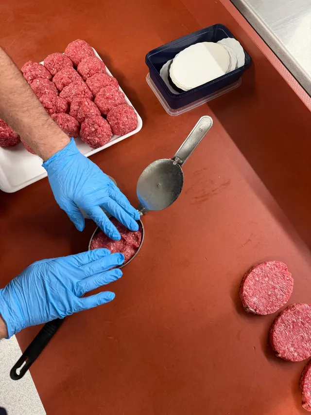 Verse hamburgers die met de hand geperst worden in het atelier van Bronckaers