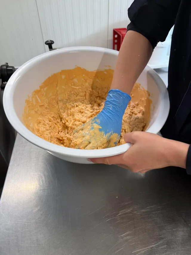 In het atelier wordt een salade met de hand gemengd in een grote kom