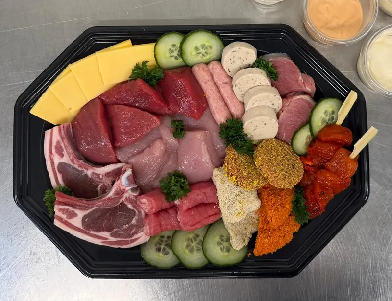 Steengrillschotel met koteletten, biefstuk, kip, worstjes, gepaneerde stukjes, paprikaspiesjes en kaas
