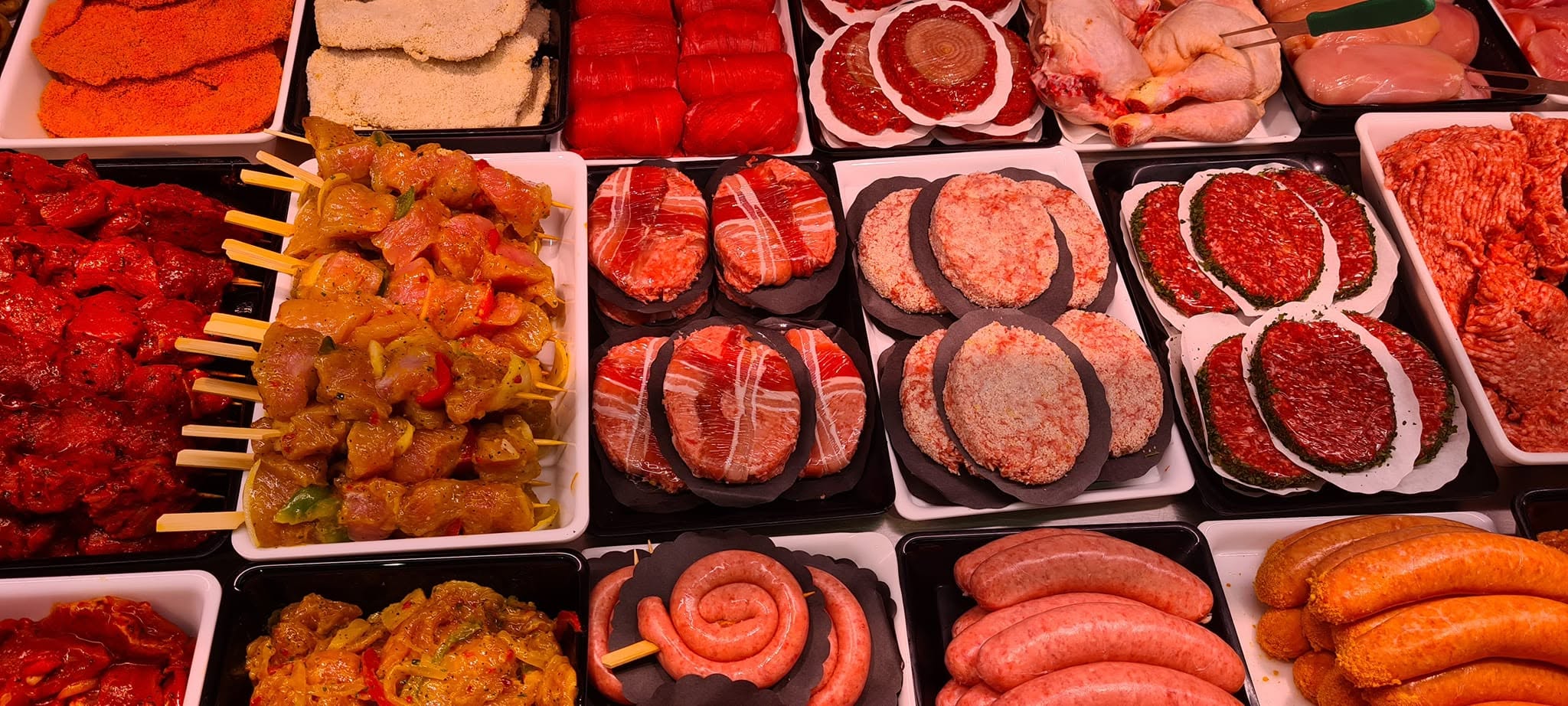 Toog met kipspiesen, gepaneerde schnitzels, gevulde burgers, verse worsten en kip